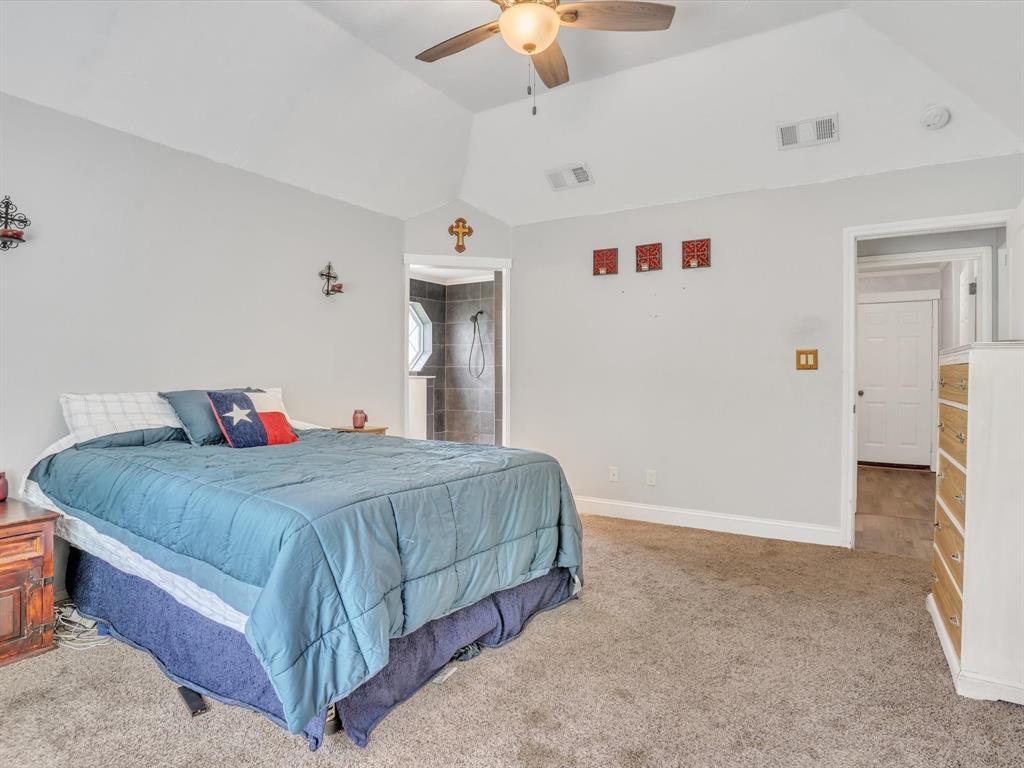15067 Meadow Ridge Court Nevada, TX 75173 - Photo 26 of 39 a bedroom with a bed and a chandelier