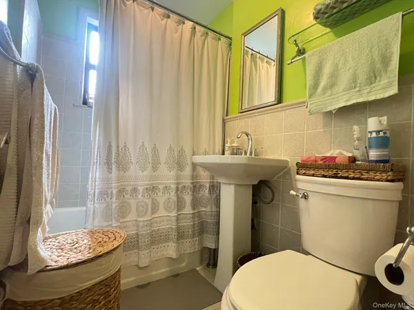 a bathroom with a sink a toilet and shower curtain