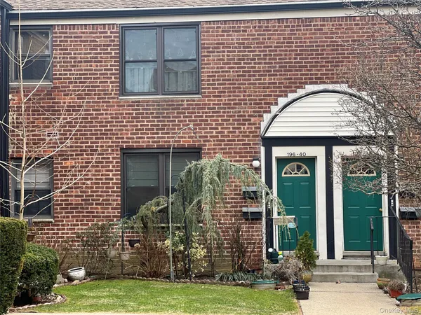 a view of a brick house with a yard and large windows