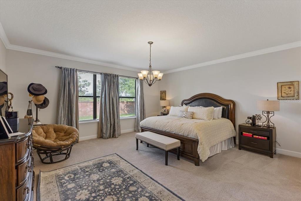 7180 Beek Street Windermere, FL 34786 - Photo 11 of 33 a spacious bedroom with a bed and a chandelier