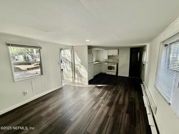 a view of a living room hardwood floor and a window