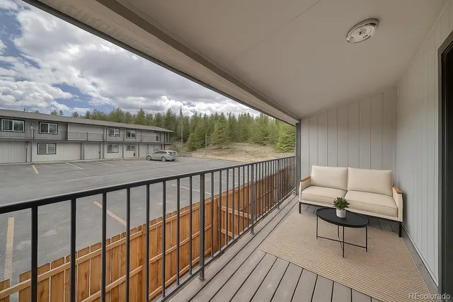 a balcony with wooden floor and outdoor seating
