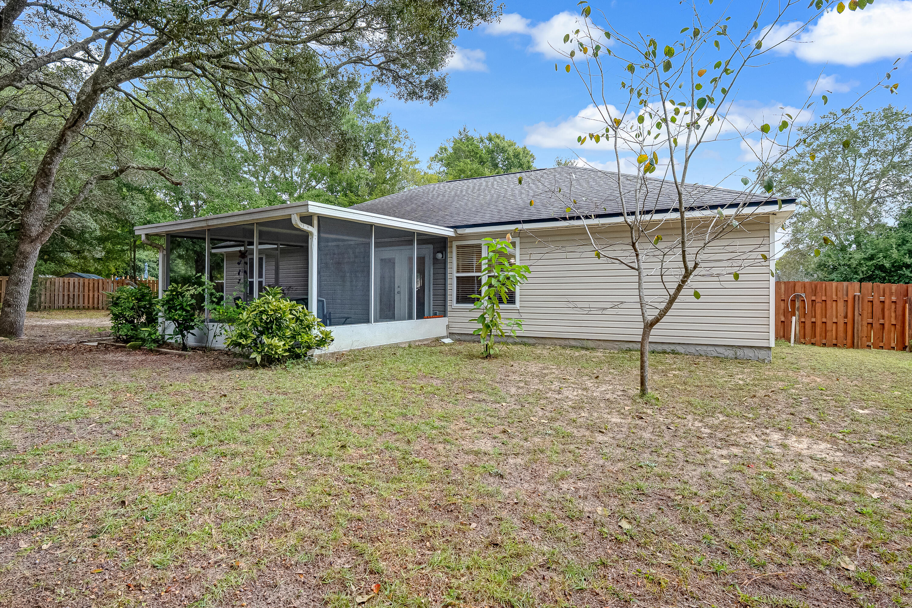 4730 Connor Drive Crestview, FL 32539 - Photo 61 of 71 a backyard of a house with plants and large tree