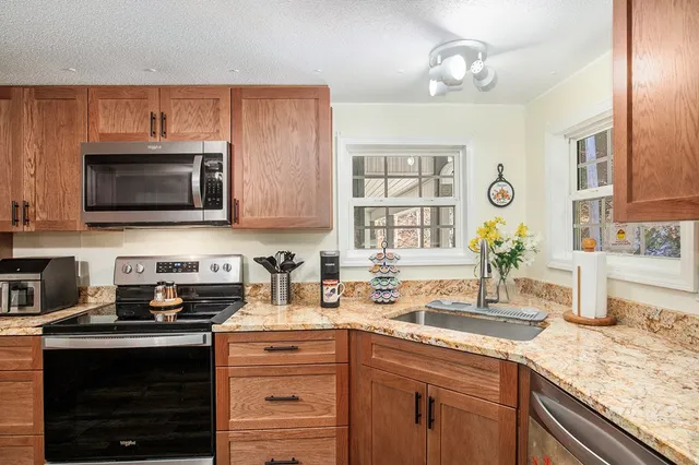 a kitchen with stainless steel appliances granite countertop a sink stove and microwave