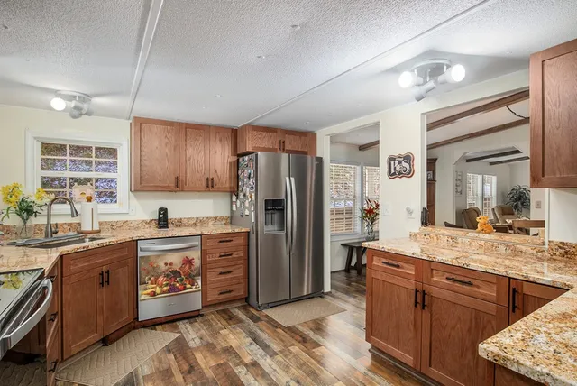 a kitchen with stainless steel appliances granite countertop a sink stove and refrigerator