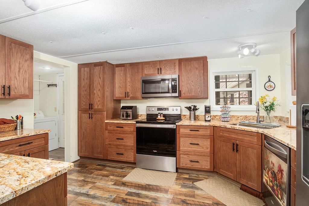 2226 Layson Road Hiawassee, GA 30546 - Photo 15 of 38 a kitchen with stainless steel appliances granite countertop a stove top oven a sink dishwasher and a refrigerator with wooden cabinets