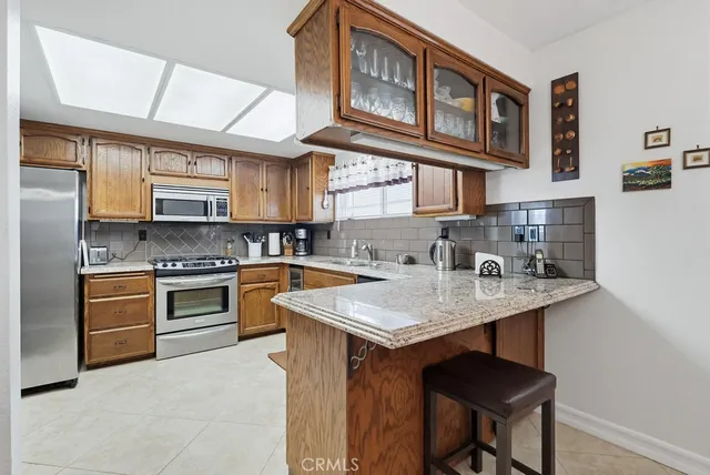 a kitchen with stainless steel appliances granite countertop a stove a sink and a microwave