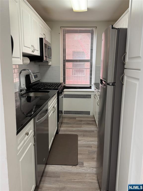100 Prospect Avenue, Unit 2E Hackensack, NJ 07601 - Photo 9 of 16 a kitchen with a stove a refrigerator and a sink
