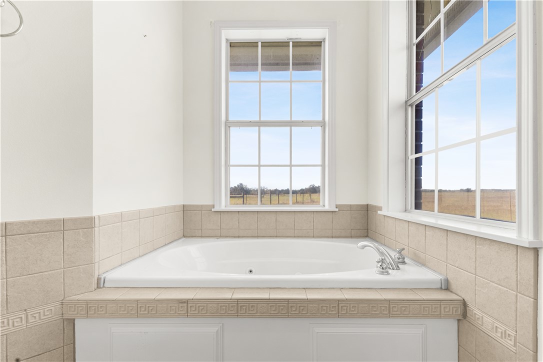 2120 Hohenwalde School Road Brenham, TX 77833 - Photo 17 of 30 a bathroom with bathtub and window