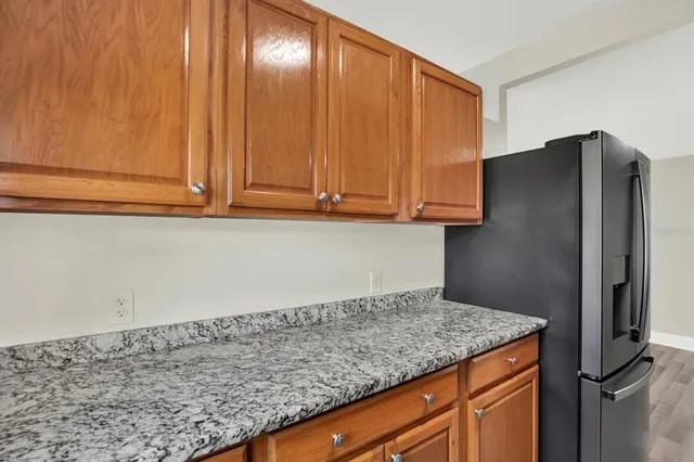 a kitchen with stainless steel appliances granite countertop cabinets and refrigerator