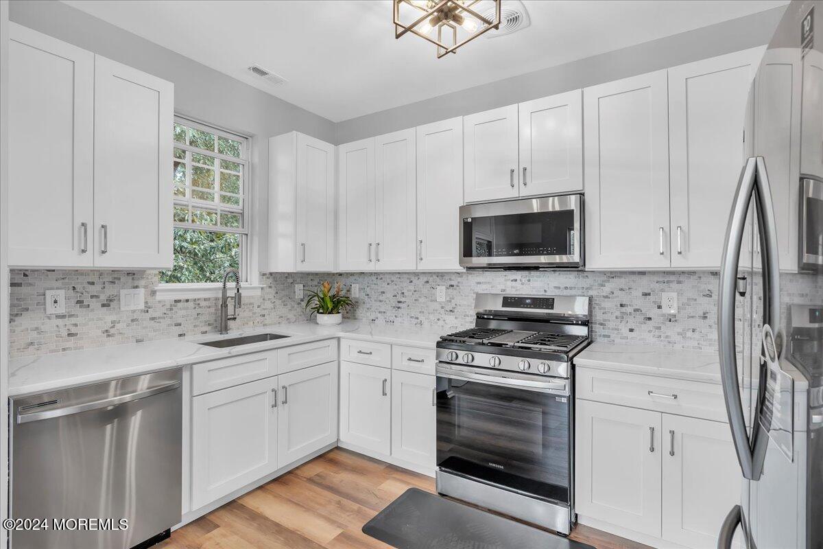 7701 Juniper Lane Palmyra, NJ 08065 - Photo 11 of 31 a kitchen with a sink stove and white cabinets