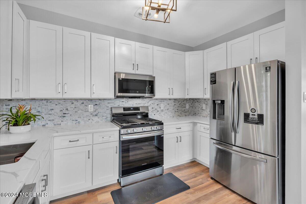 7701 Juniper Lane Palmyra, NJ 08065 - Photo 12 of 31 a kitchen with cabinets stainless steel appliances and wooden floor
