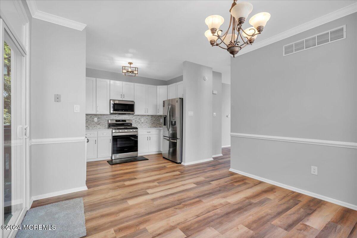 7701 Juniper Lane Palmyra, NJ 08065 - Photo 8 of 31 a kitchen with a chandelier stainless steel appliances cabinets and a counter top space
