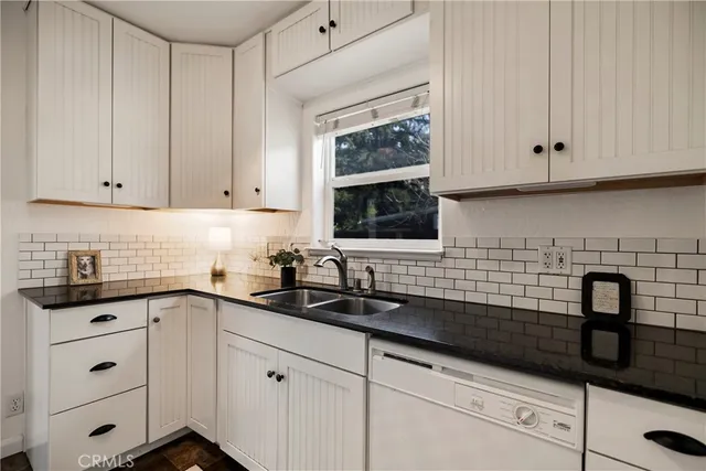 a kitchen with granite countertop white cabinets and white appliances