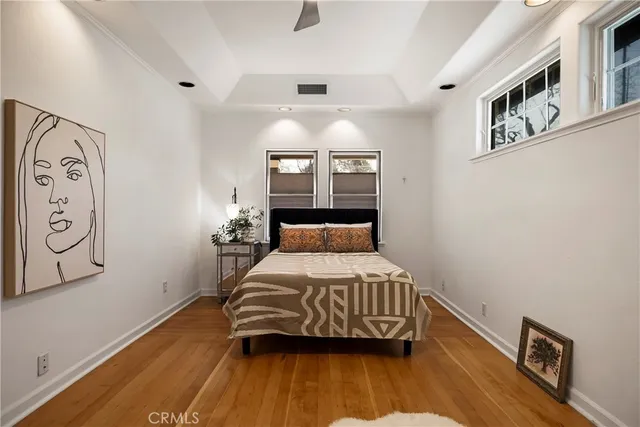 a bedroom with a bed and wooden floor