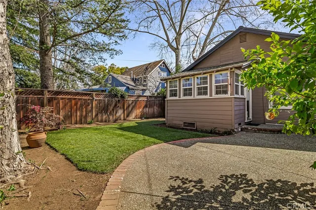 a front view of a house with a yard and trees