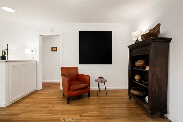 a living room with furniture a flat screen tv and a wooden floor