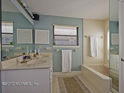 49 Solana Road Ponte Vedra Beach, FL 32082 - Photo 9 of 16 a bathroom with a tub a sink and mirror