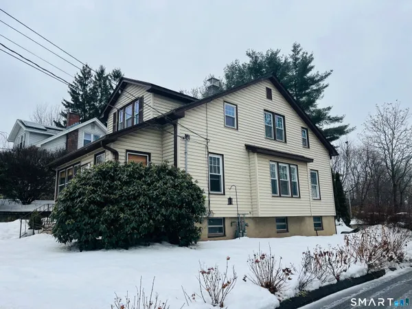a view of a house with a yard covered in snow