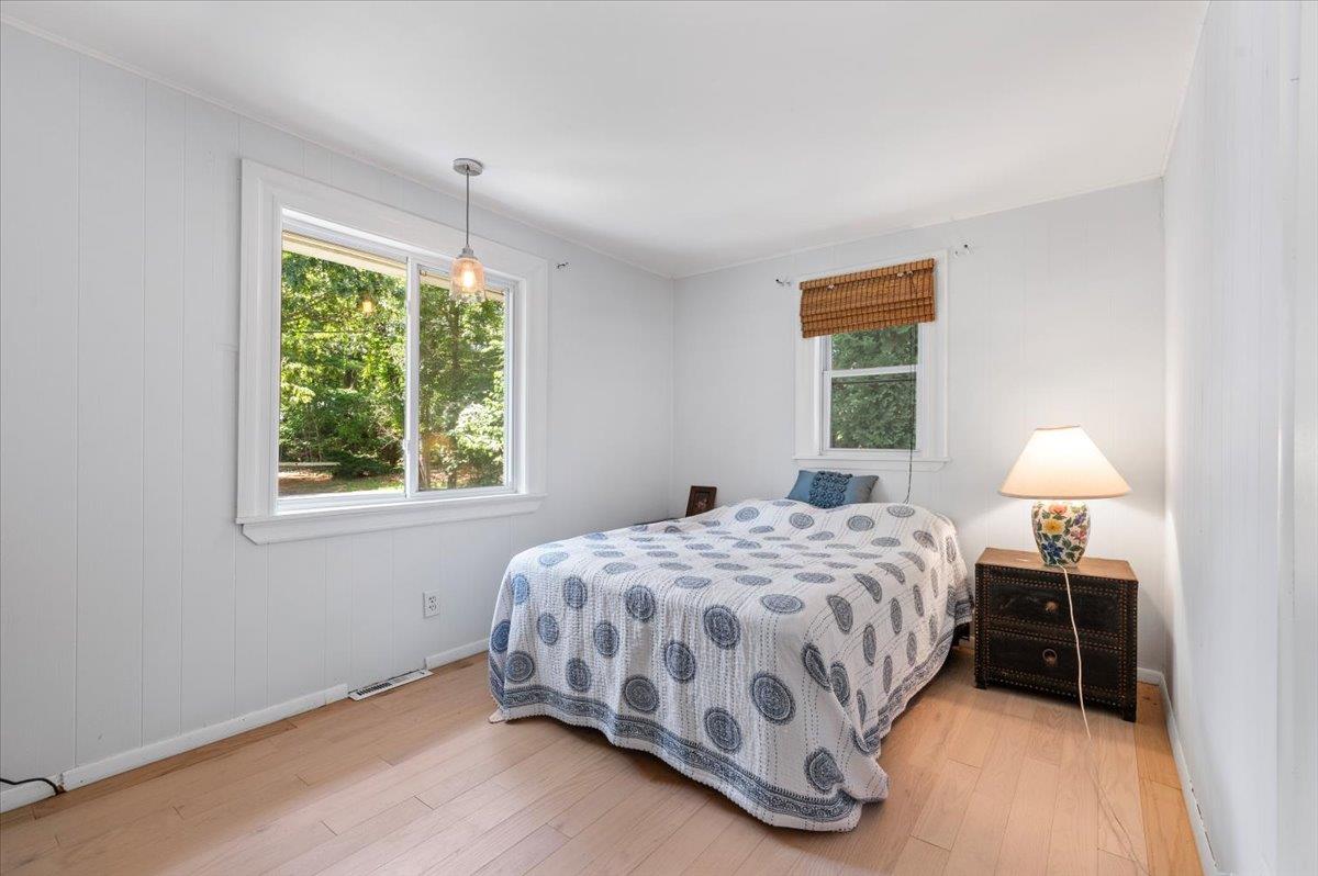 56 West Donellan Road Hampton Bays, NY 11946 - Photo 15 of 27 a bedroom with a bed lamp and a window