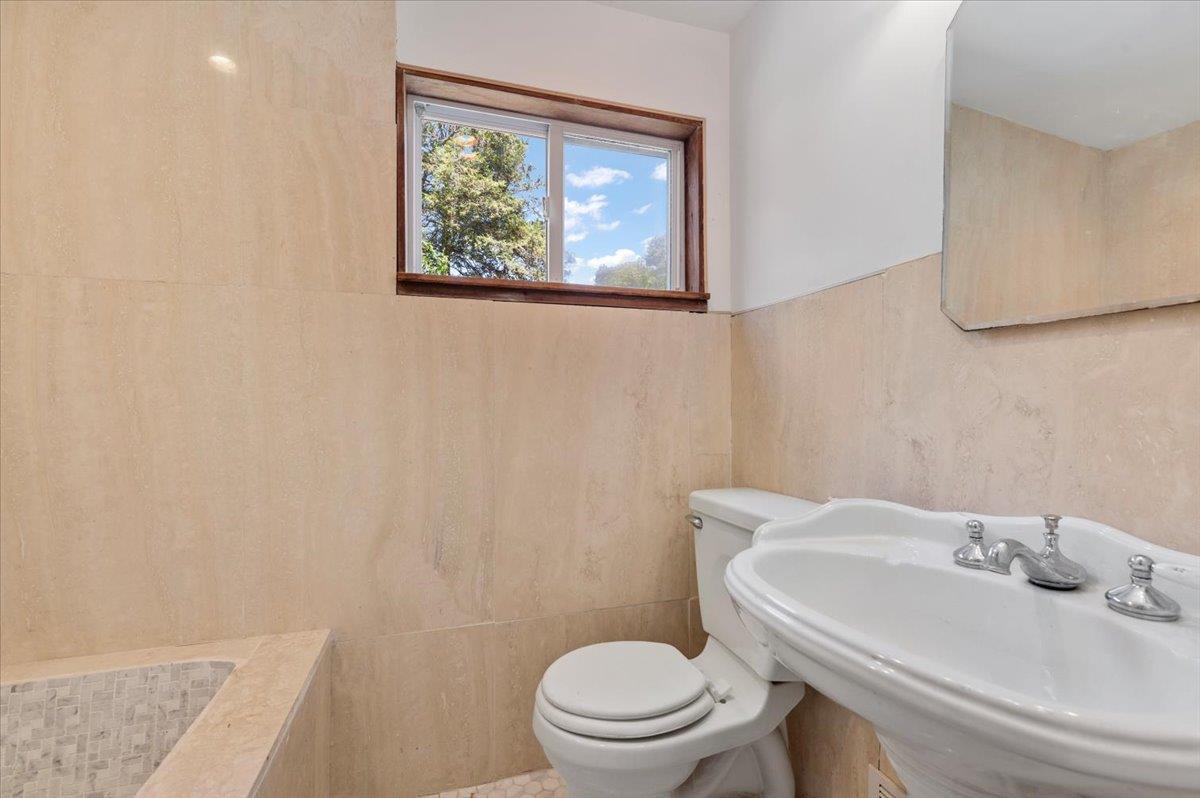 56 West Donellan Road Hampton Bays, NY 11946 - Photo 21 of 27 a bathroom with a sink a toilet and a mirror
