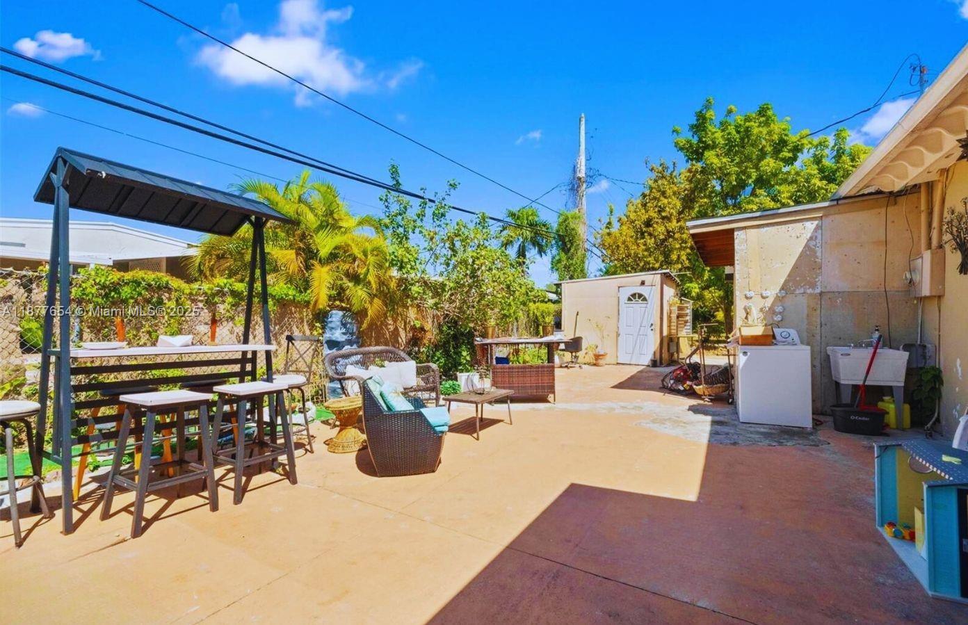 8571 Southwest 30th Street Miami, FL 33155 - Photo 14 of 15 a view of a patio with table and chairs potted plants and a large tree
