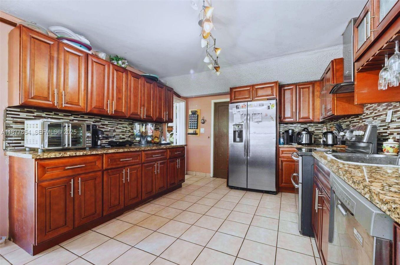 8571 Southwest 30th Street Miami, FL 33155 - Photo 4 of 15 a kitchen with stainless steel appliances granite countertop a refrigerator a stove and a sink