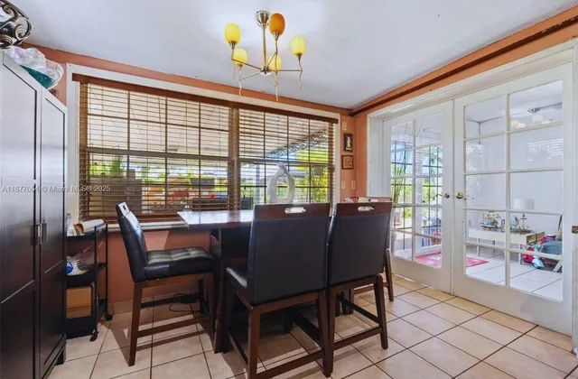 a view of a dining room with furniture a chandelier and a window