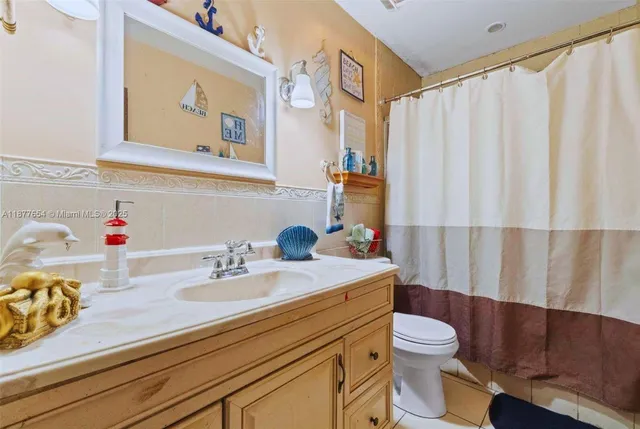 a bathroom with a sink a toilet and shower curtain