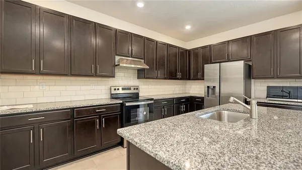 a kitchen with granite countertop stainless steel appliances and wooden cabinets