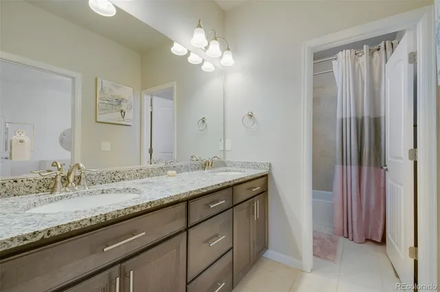 a bathroom with a granite countertop sink a toilet and shower