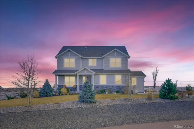 a front view of a house with a yard and lake view