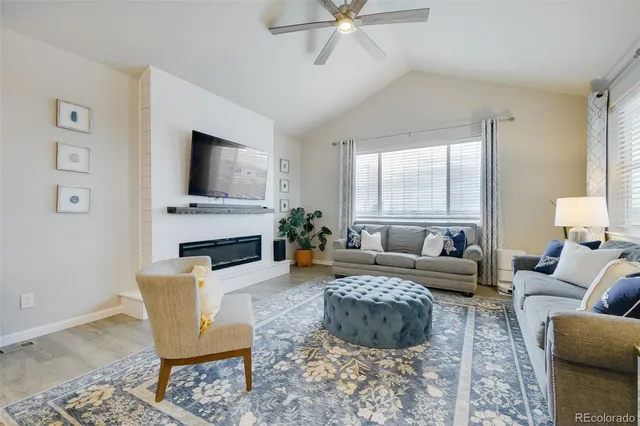a living room with furniture a fireplace and a flat screen tv