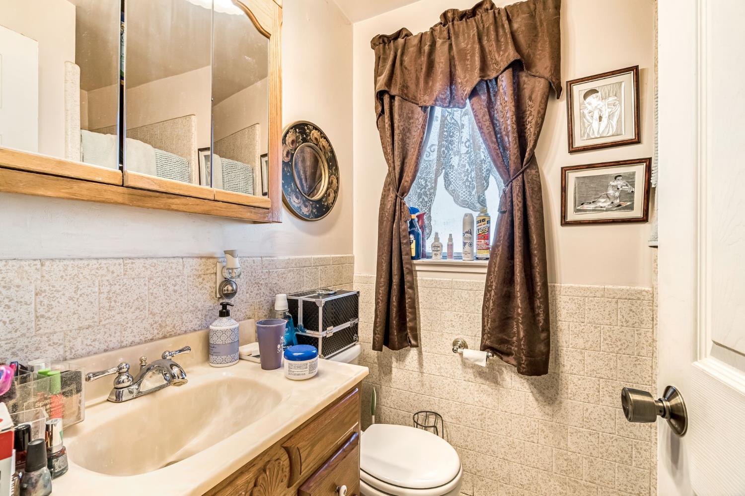 1205 Rogers Street Madera, CA 93638 - Photo 17 of 23 a bathroom with a sink a toilet and a mirror