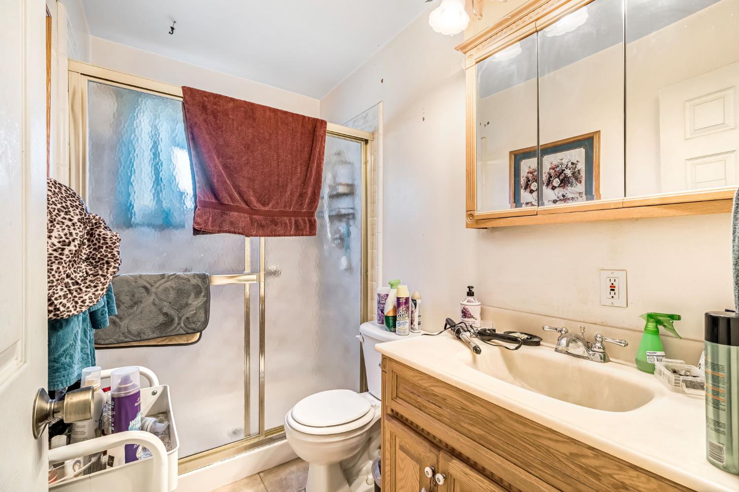 1205 Rogers Street Madera, CA 93638 - Photo 18 of 23 a bathroom with a sink a toilet and a shower curtain