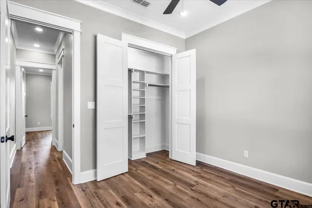 a view of a hallway with wooden floor and a living room