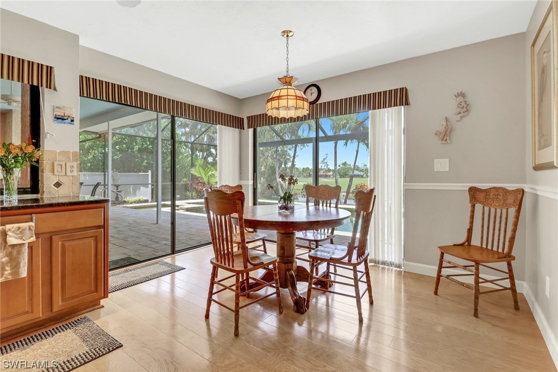 14813 Soaring Eagle Court Fort Myers, FL 33912 - Photo 4 of 19 a dining room with furniture a chandelier and wooden floor