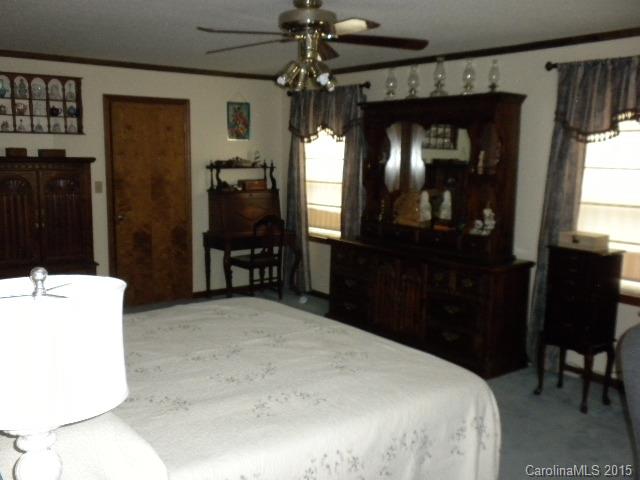 1813 Claude Austin Road Monroe, NC 28112 - Photo 11 of 22 a bed room with a bed mirror and a chair