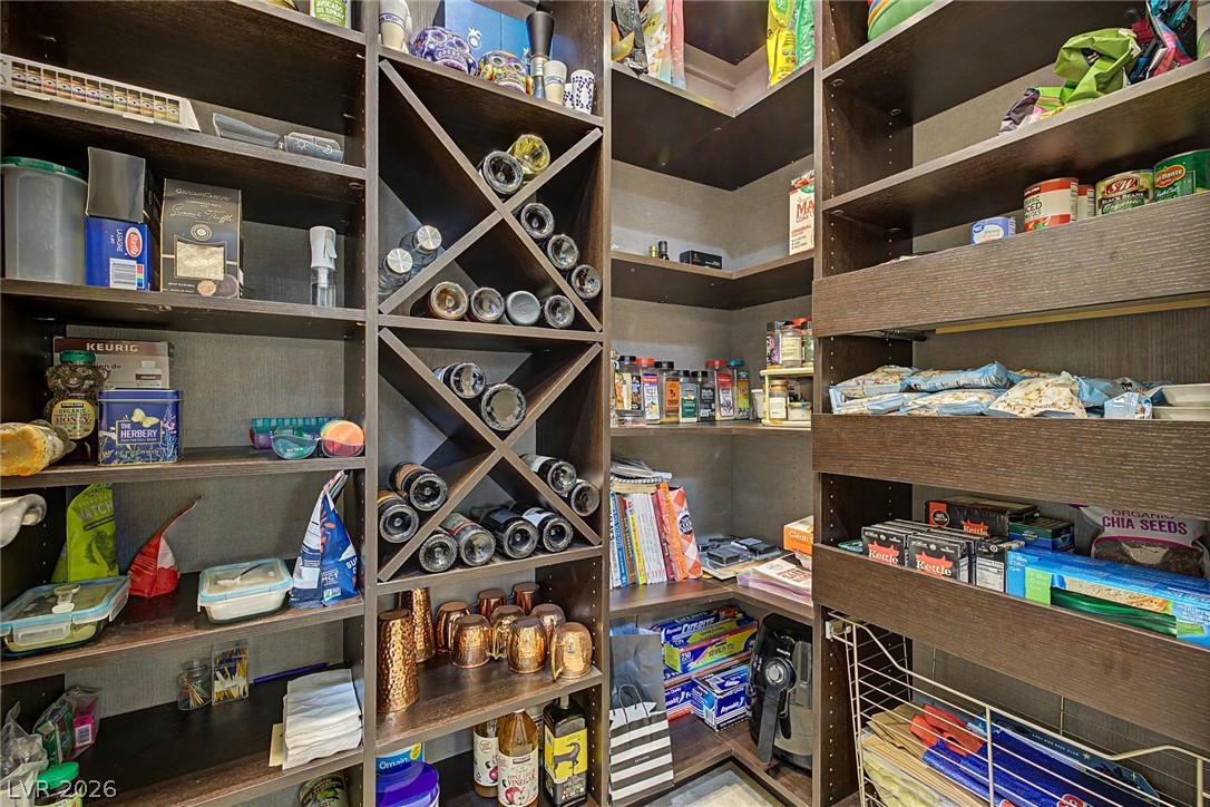 7415 Campbell Ranch Avenue Las Vegas, NV 89179 - Photo 22 of 52 Custom-built shelving and a dedicated wine rack maximize storage capacity within this organized pantry.