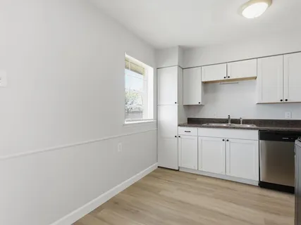 a kitchen with granite countertop white cabinets and white appliances