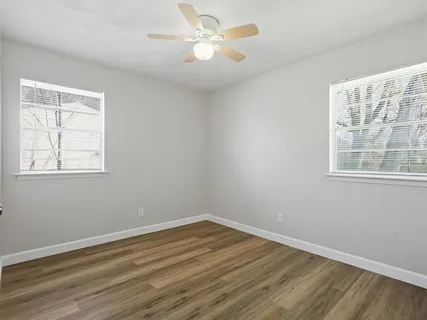 a view of a room with wooden floor and windows