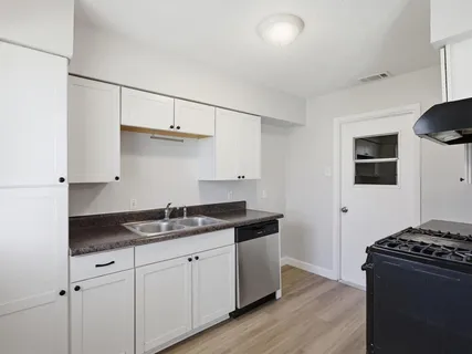 a kitchen with granite countertop a sink and a stove