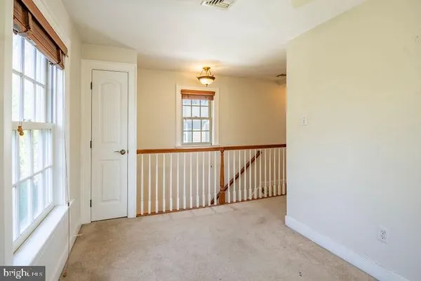 a view of a big room with windows and chandelier fan