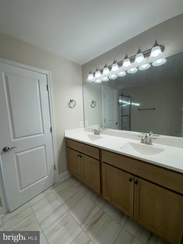 a bathroom with a double vanity sink and a mirror