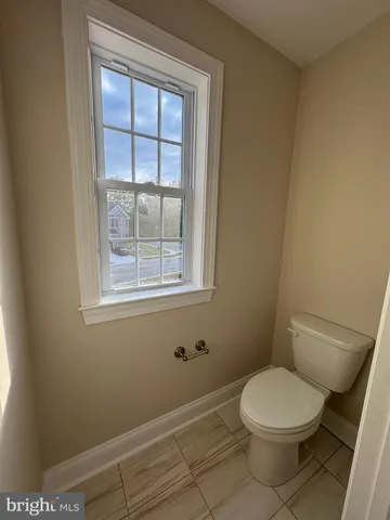 a white toilet sitting next to a window