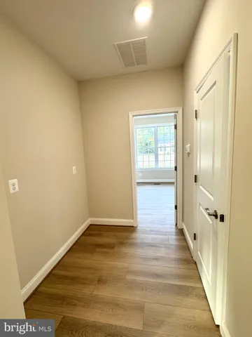 an empty room with wooden floor and a window