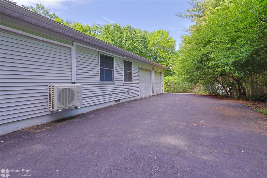 60 Sassafras Road Lehighton, PA 18235 - Photo 12 of 51 A spacious asphalt driveway leads to a side-facing garage, enveloped by verdant trees.