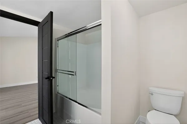 a bathroom with a granite countertop toilet and a shower