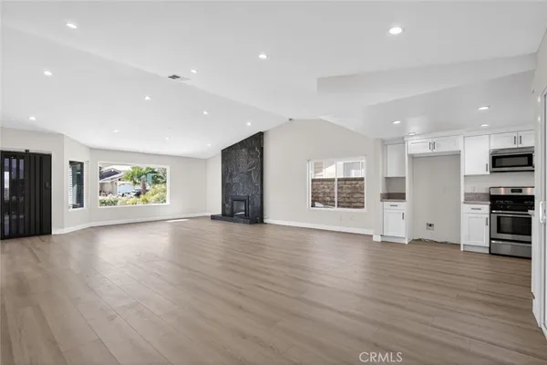 an empty room with wooden floor and window