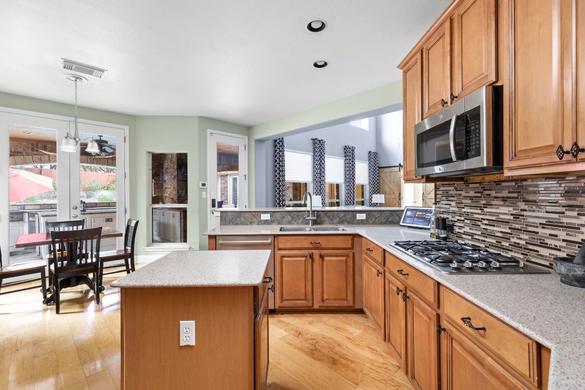 7109 Via Correto Drive Austin, TX 78749 - Photo 11 of 40 a kitchen with stainless steel appliances granite countertop a sink stove and cabinets